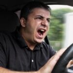 angry man driving a vehicle without seat belt