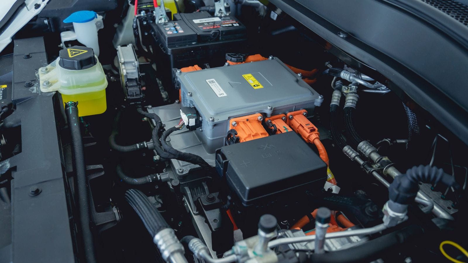 Electric vehicle with open hood and details of electric car engine