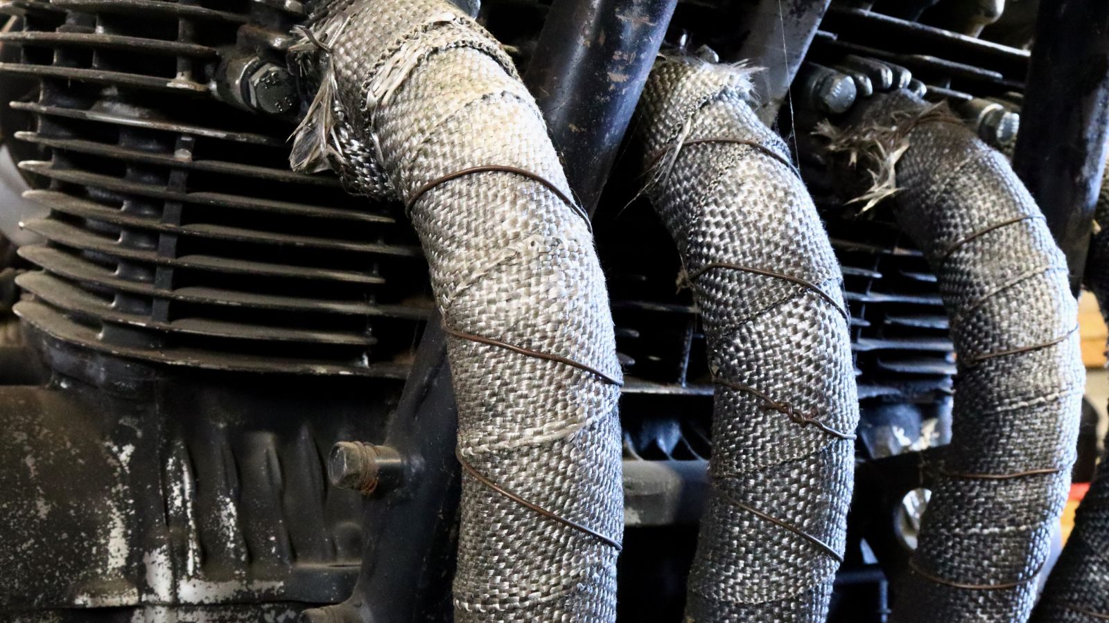 Heat wrapped exhaust of four cylinder cafe racer engine