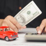 Man calculates auto loan or car investment