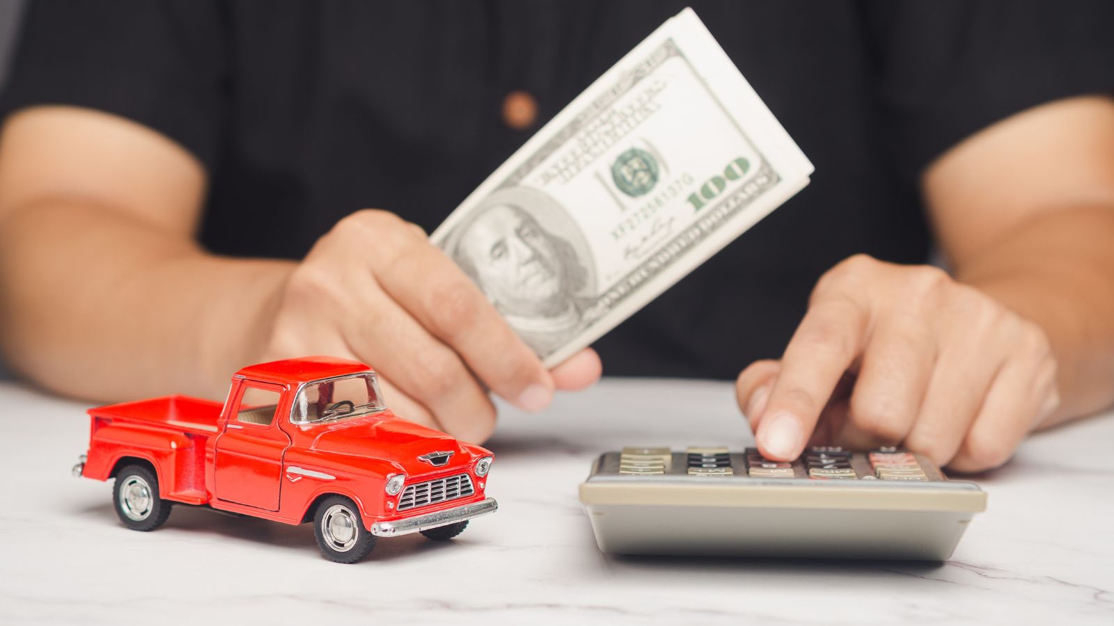 Man calculates auto loan or car investment