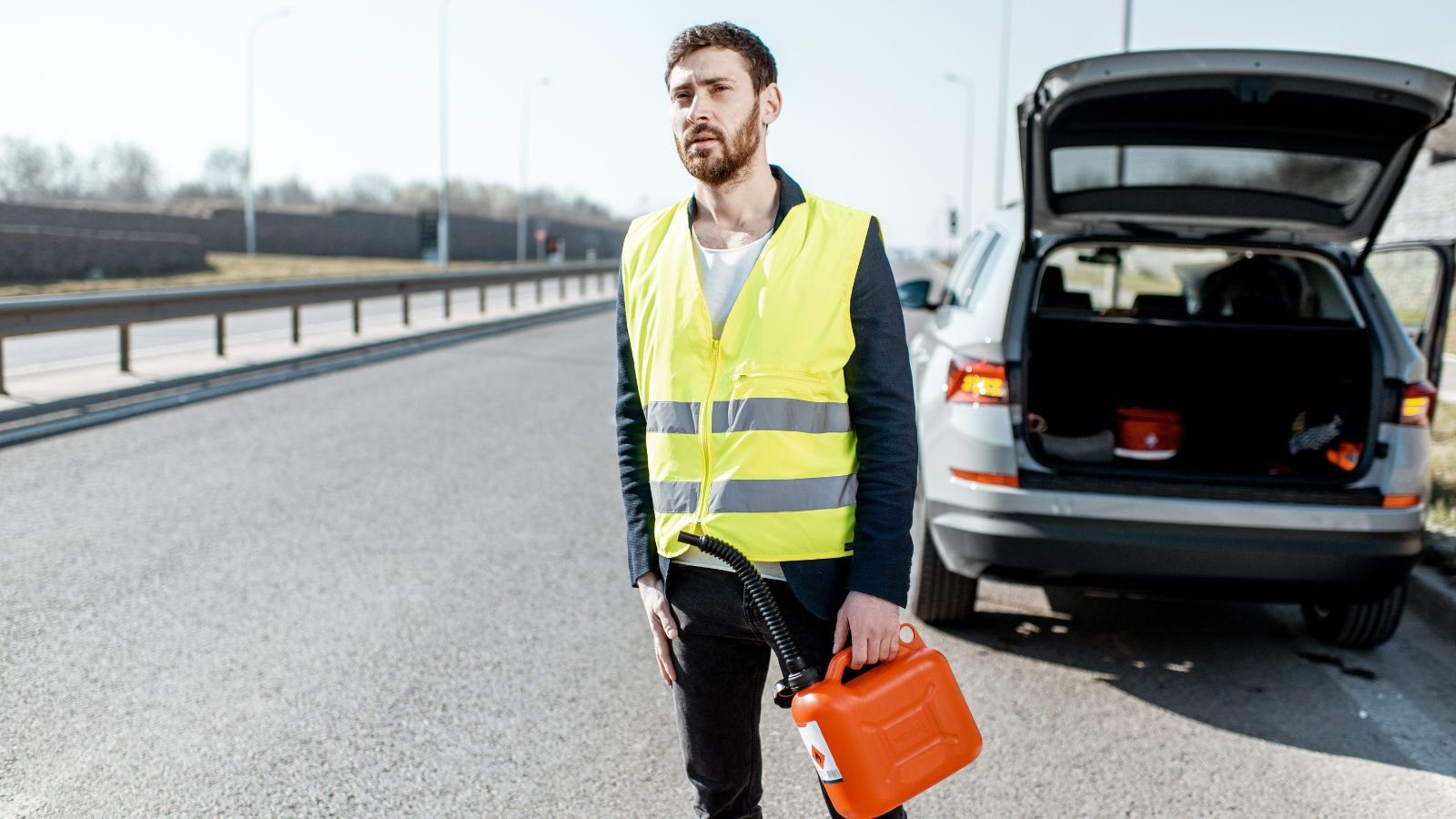 Man with despair emotions waiting for the car to refuel gasoline standing with canister on the roadside