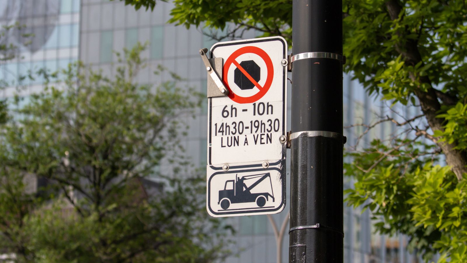 Quebec, Canada, 05 July 2025 : No stopping sign with times and tow truck warning attached nearby