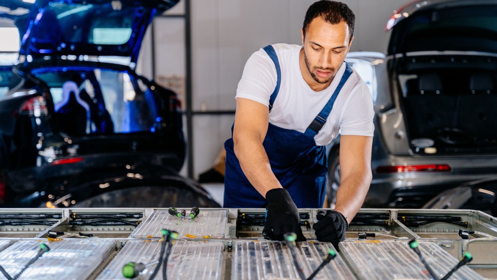 Portrait of biracial male expert technician repair electric car