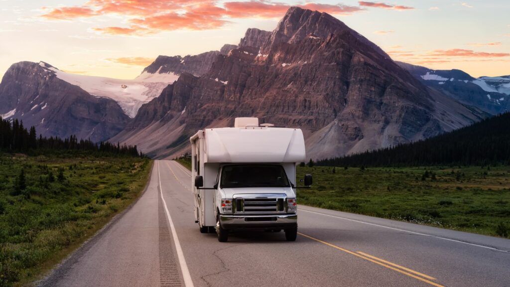 White RV Driving on route. Taken in Icefields Parkway, Banff National Park, Alberta, Canada.