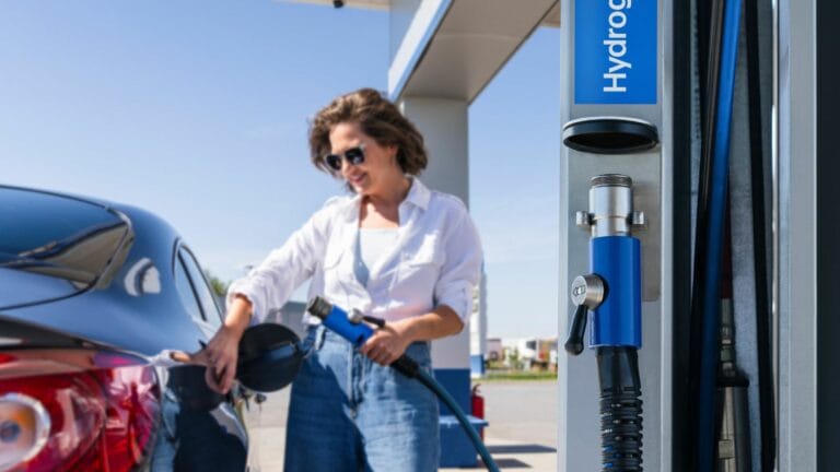 Woman holds a hydrogen fueling nozzle on a hydrogen filling station