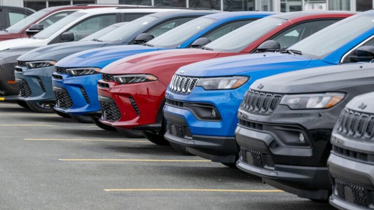 Newfoundland, Canada - March 1, 2025: A row of new blue, black, grey, and red Jeep utility vehicles on the parking lot of a car dealership. The modern vehicles are electric rechargeable automobiles.