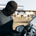 car thief with laptop hacking
