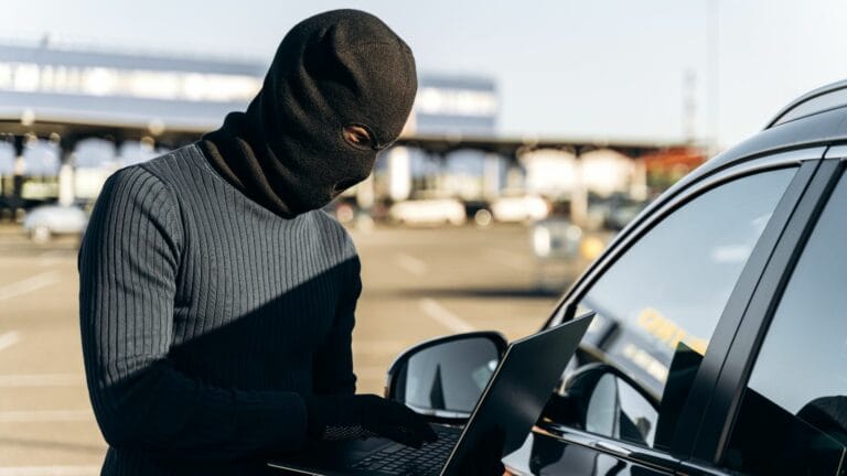 car thief with laptop hacking