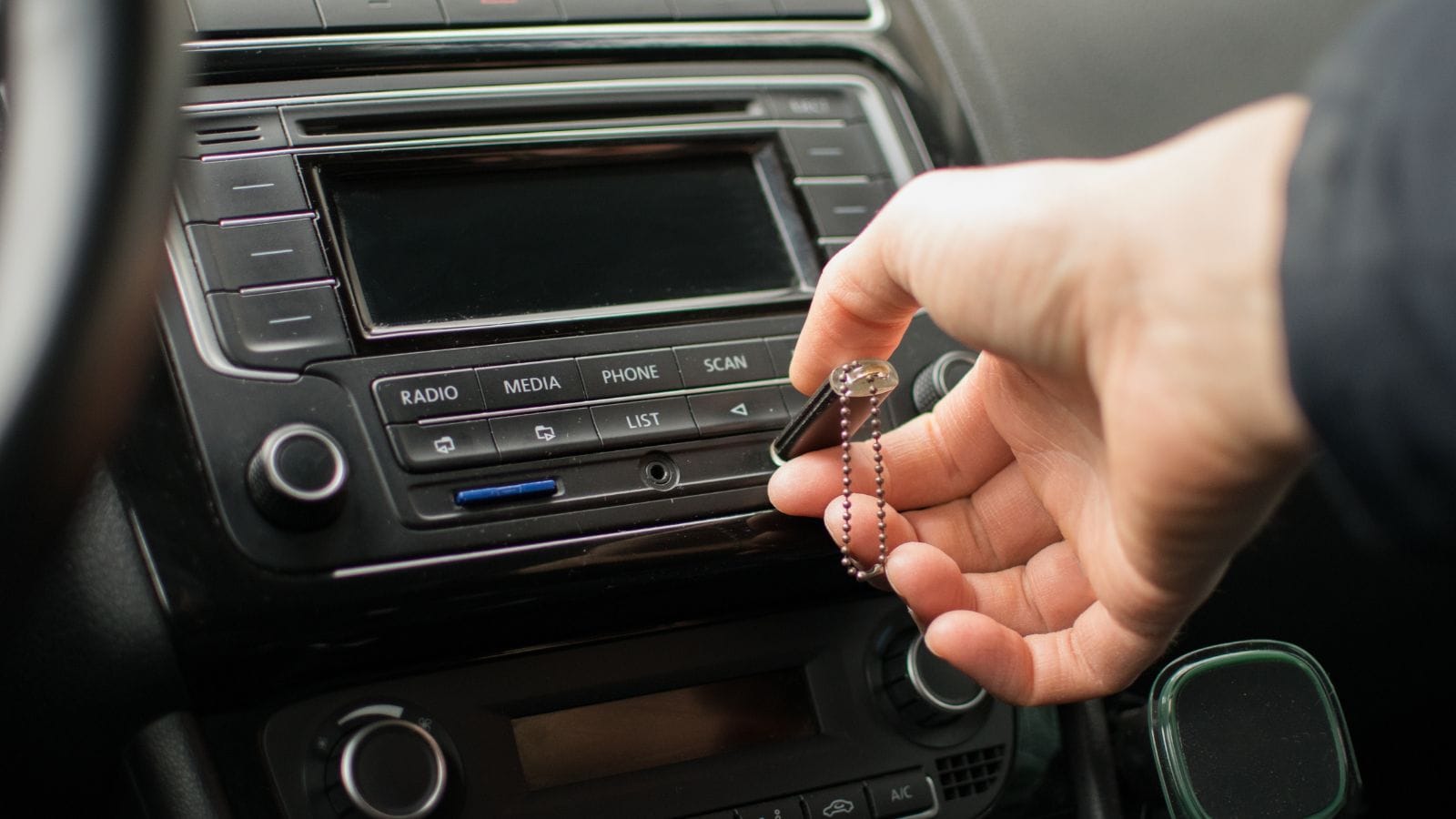 driver's hand inserting a USB flash drive
