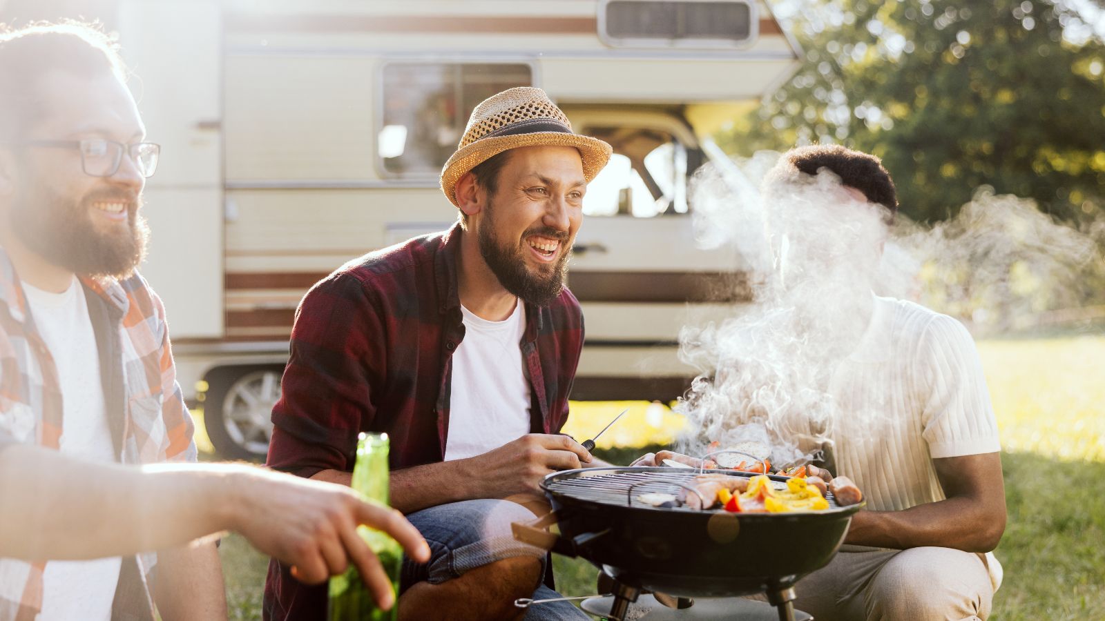 A bearded middle-aged guy is preparing a barbecue for friends. A group of college boys hang out together. RV trip