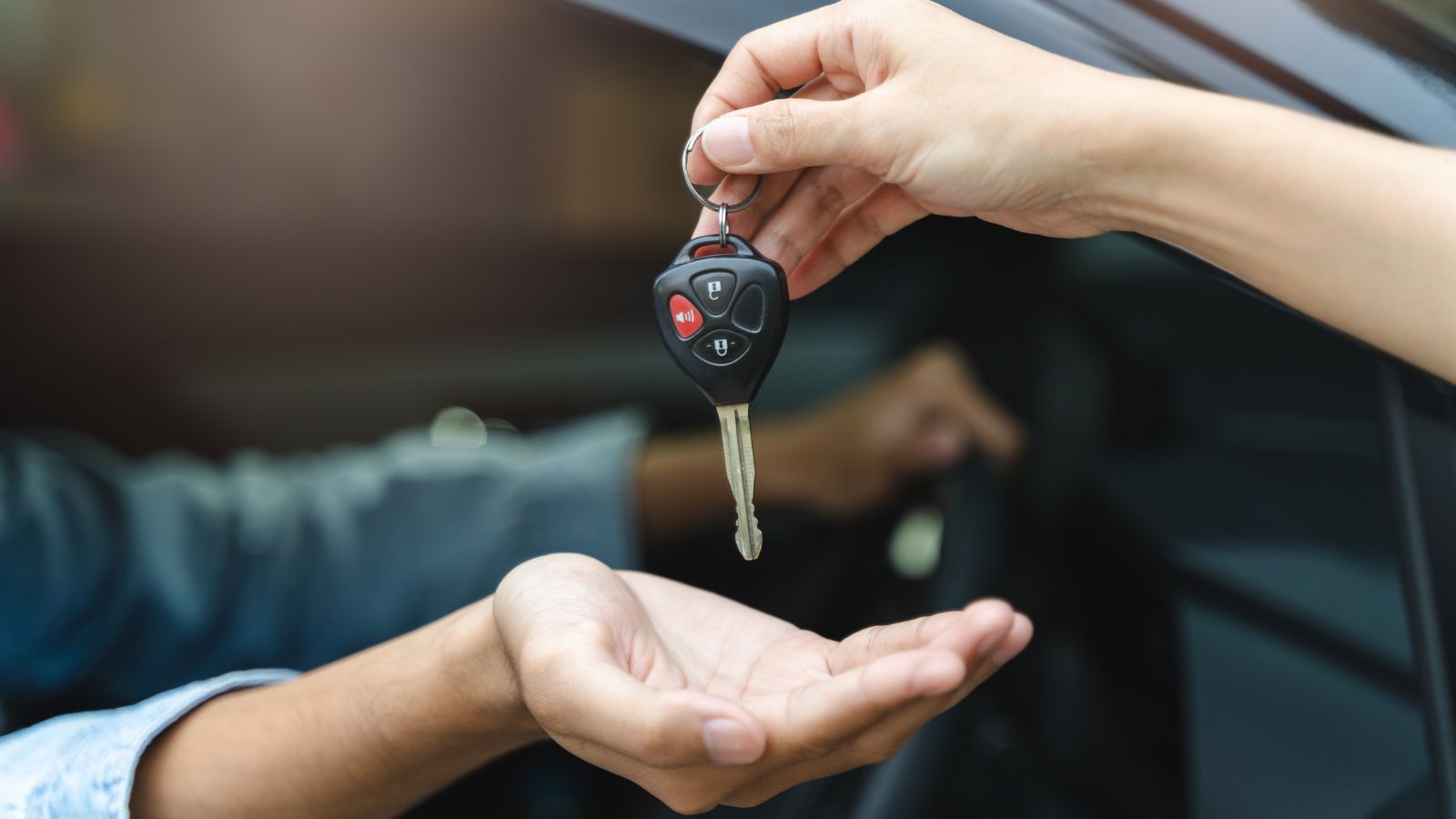 Buy second-hand auto or rent a car concept, Close-up hand of used car agent giving an auto key to client