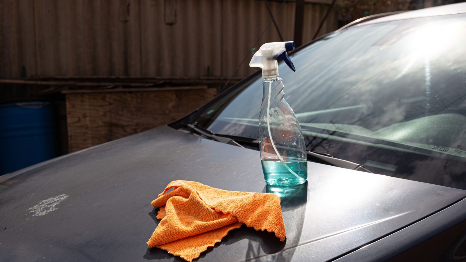 Car cleaning concept. Spray bottle with blue liquid and an orange microfiber