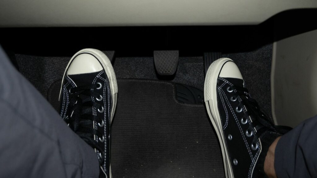 Foot stepping on the accelerator and clutch pedal in manual car