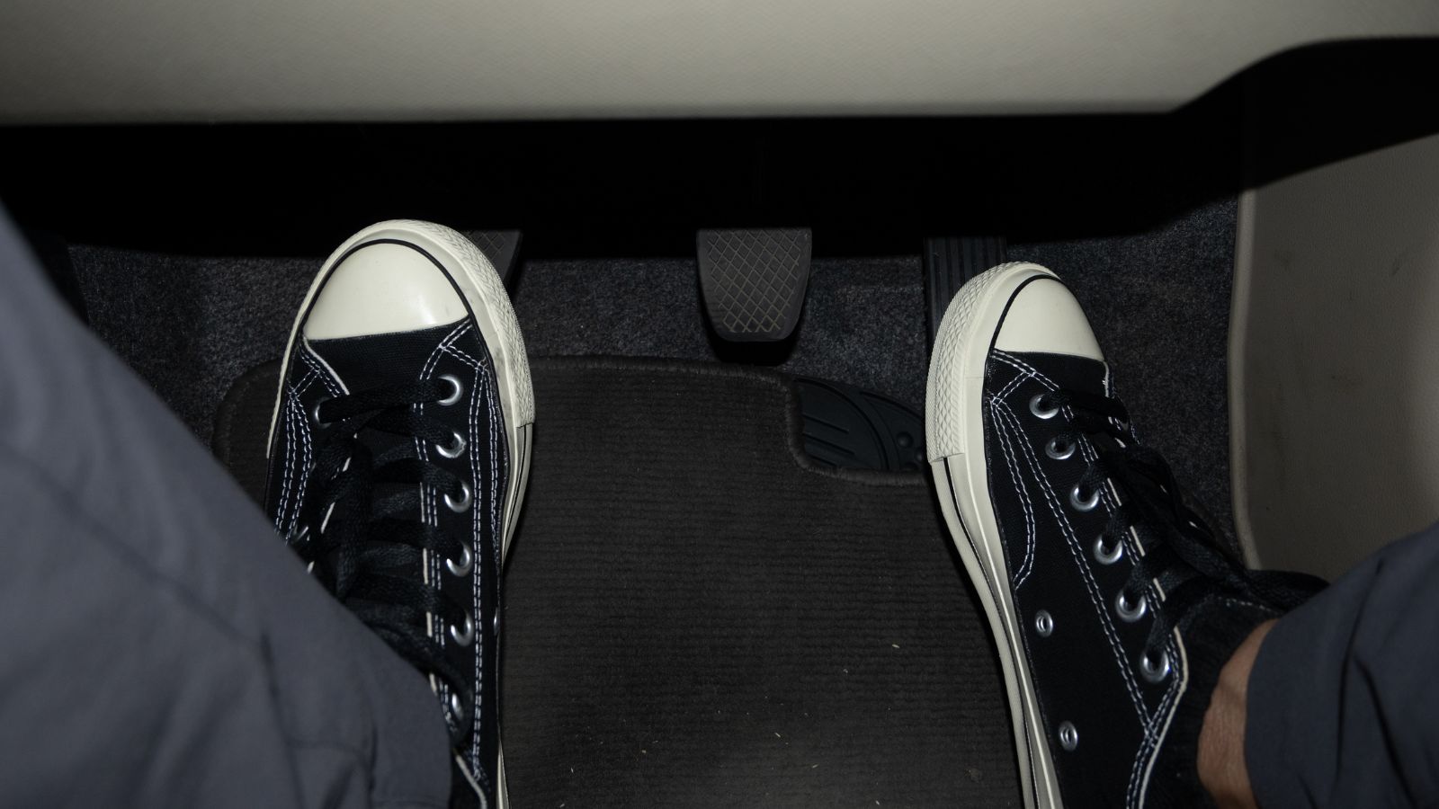 Foot stepping on the accelerator and clutch pedal in manual car