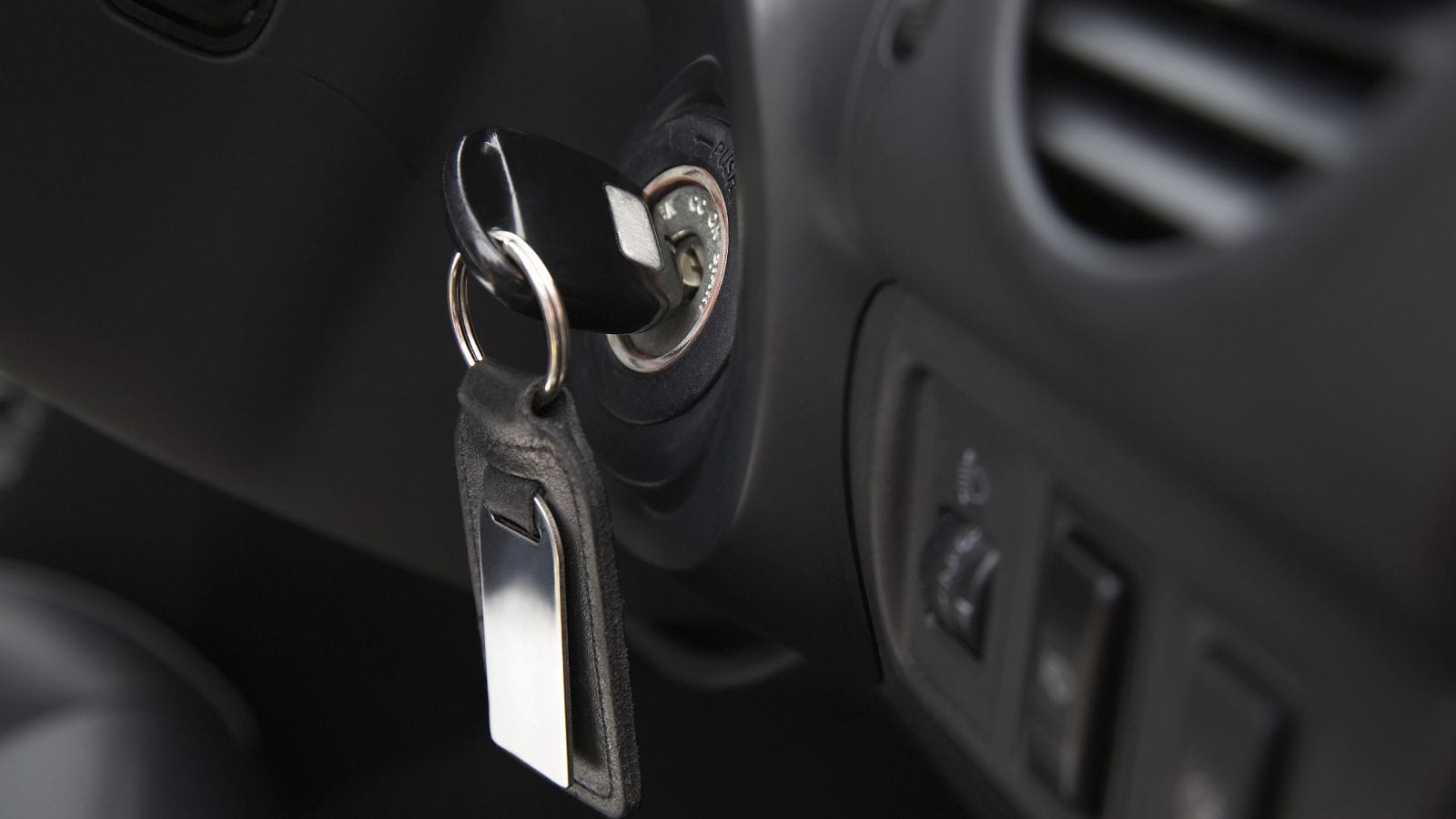 Key inserted into the lock of ignition of the car