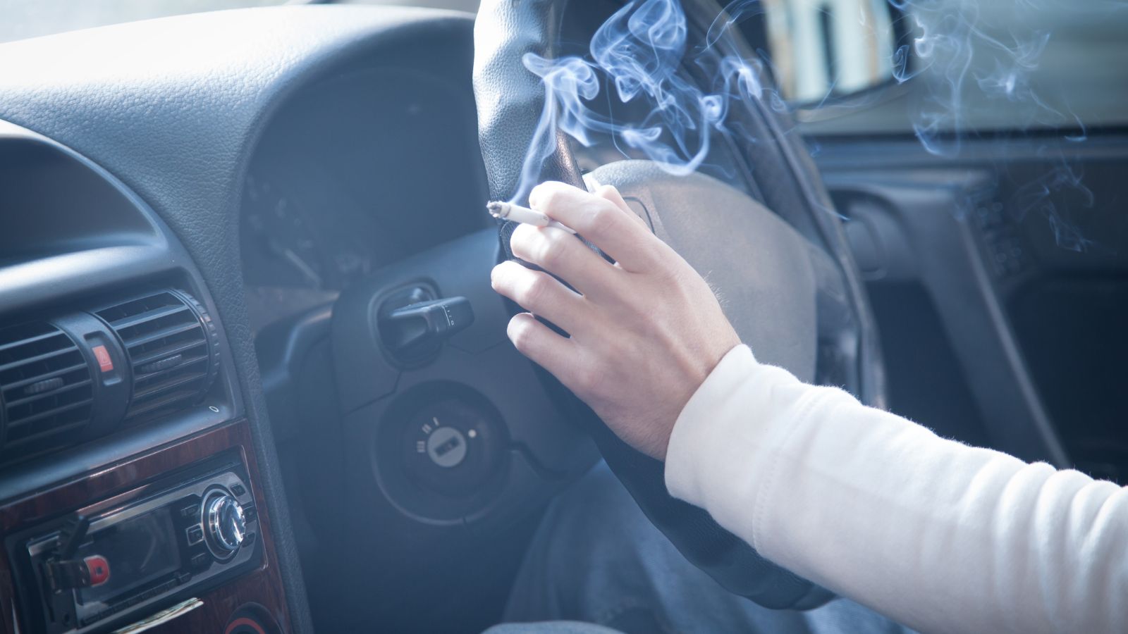 Man smoking a cigarette at the wheel of a car