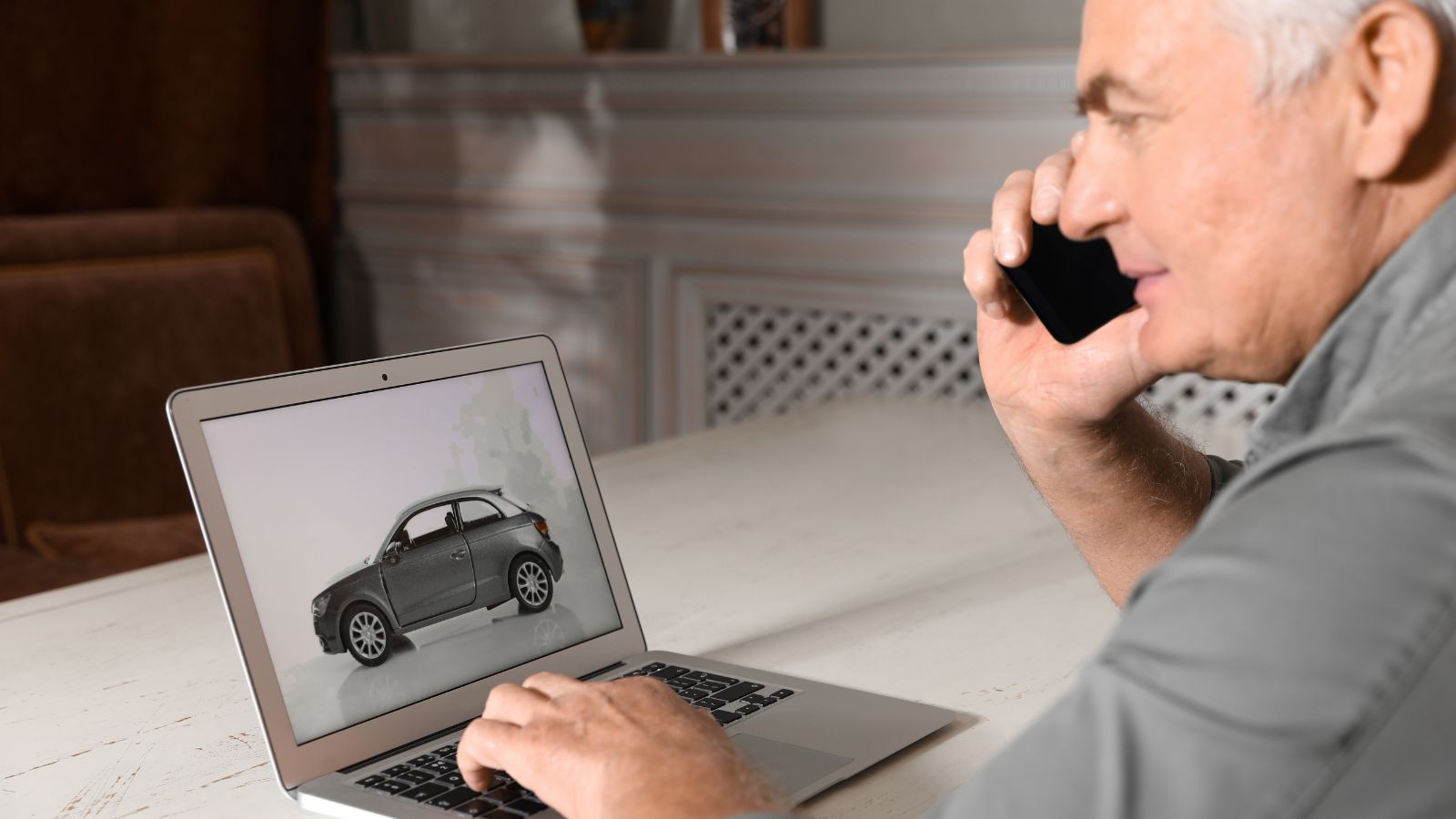 Man using laptop to buy car