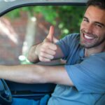 Portrait of happy man showing thumbs up while driving van