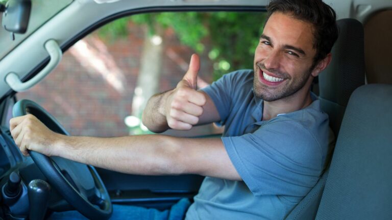 Portrait of happy man showing thumbs up while driving van