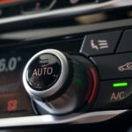 Selective focus of Vehicle Air Conditioning Control System. AC Recirculation Button on dashboard in luxury car