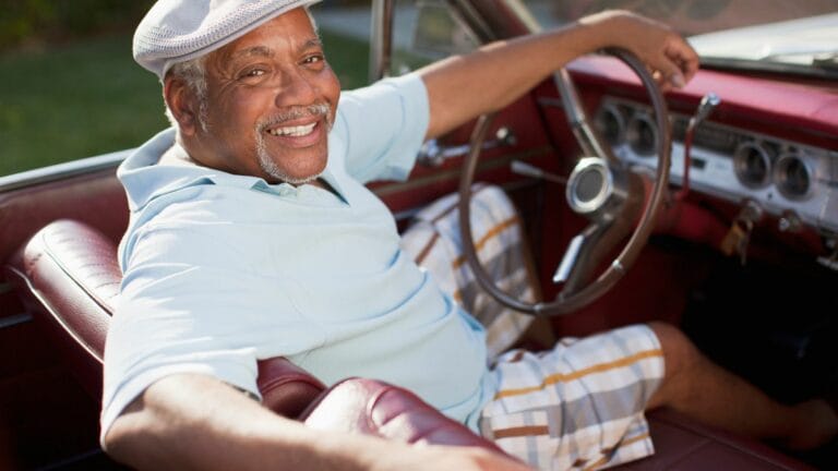 Smiling older man driving convertible, No Headrests