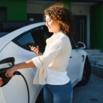 Young woman charges her electric car