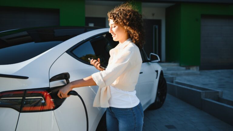 Young woman charges her electric car