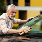 cleaning his car windshield