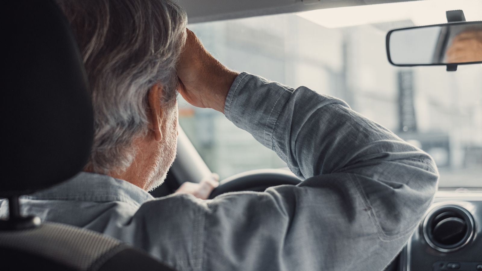 old businessman feeling headache in car